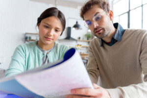 father-being-tutor-her-daughter-holding-book